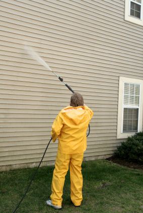 Pressure washing the siding of a house by A Brush of Color Inc.